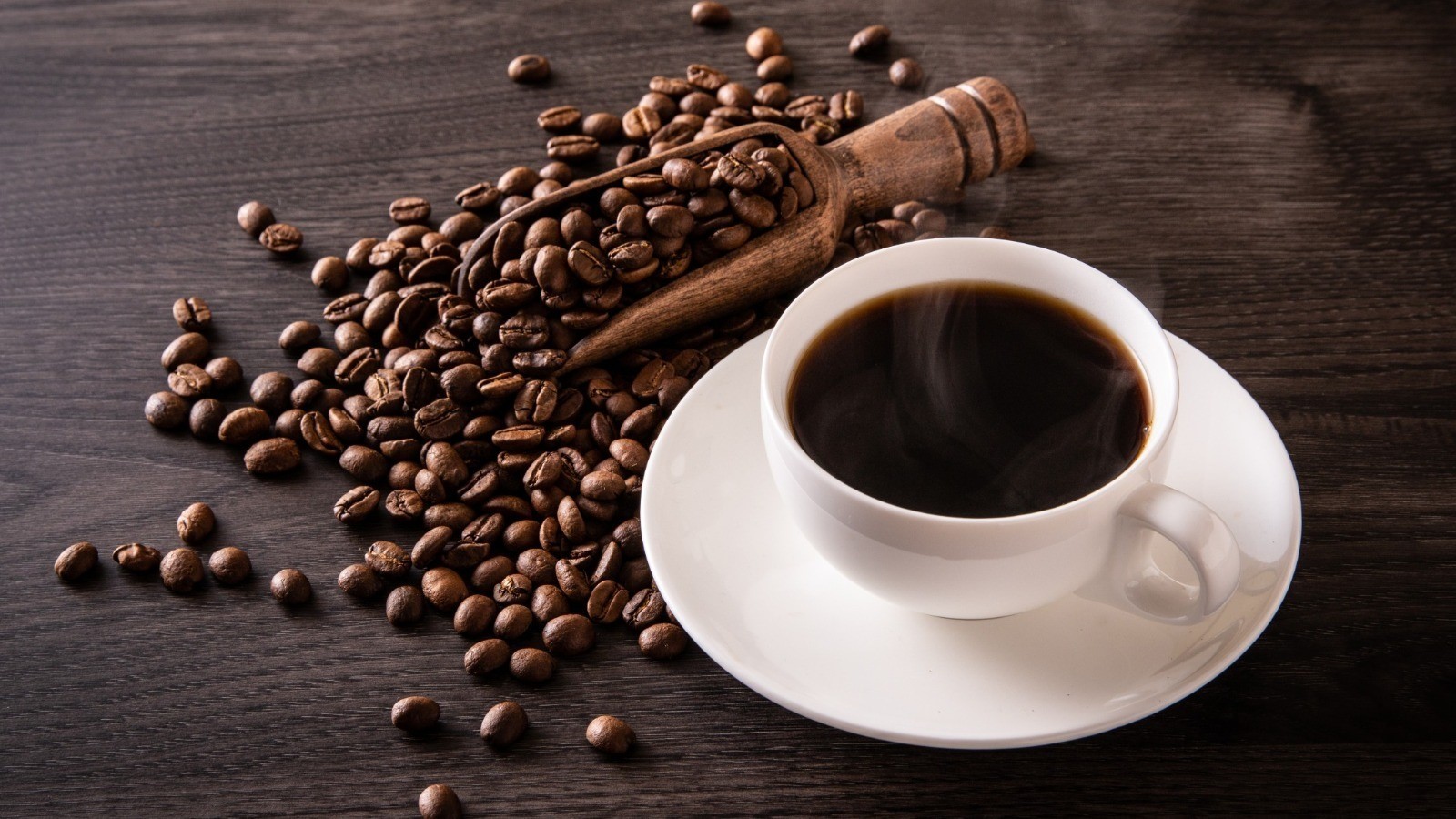 a cup of black coffee with coffee beans